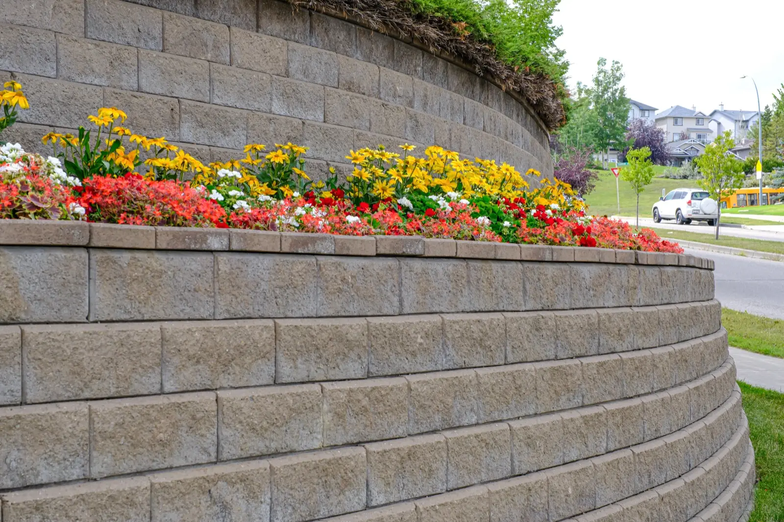 Curved segmental block retaining wall with a flower bed on its lower tier